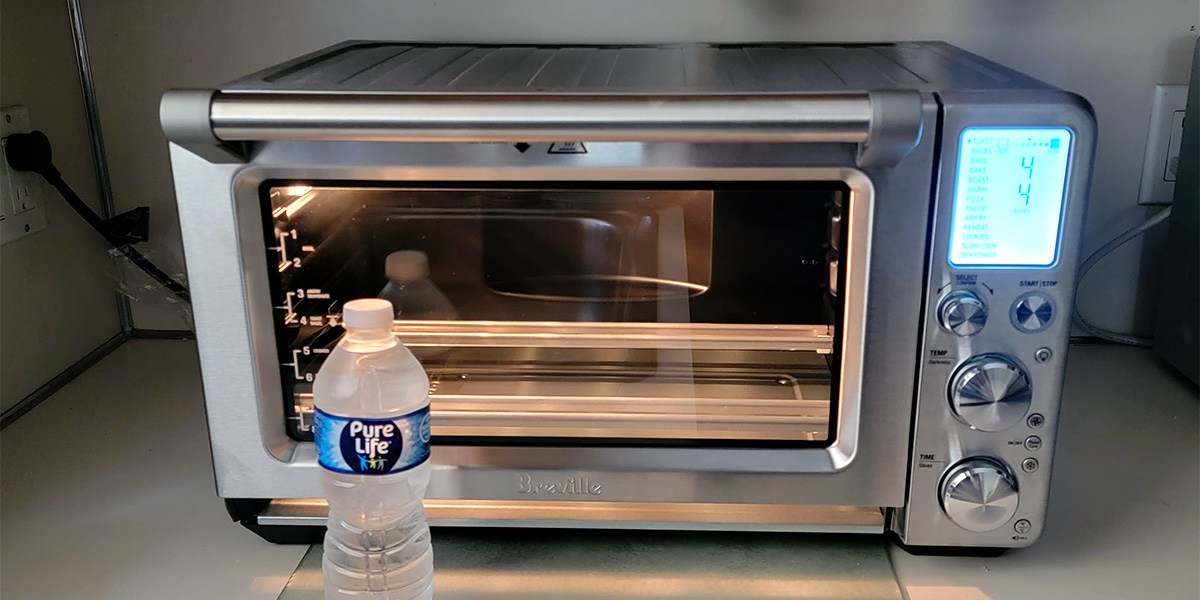 Breville Smart Oven Air Fryer Pro on counter with water bottle in front Breville Smart Oven Air Fryer Pro on counter with water bottle in front