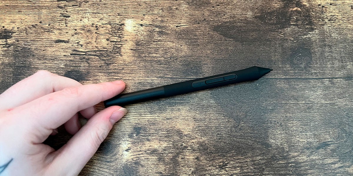 Hand holding the Wacom Intuos Small Graphics Drawing Tablet pen Hand holding the Wacom Intuos Small Graphics Drawing Tablet pen