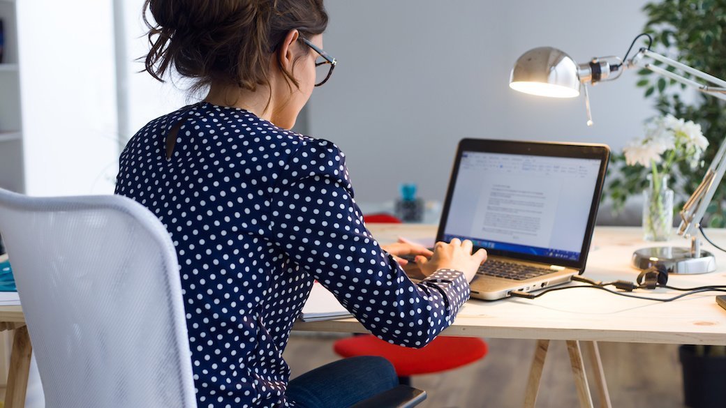 Person sitting at a desk working on a laptop