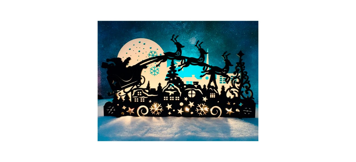 black mantel decoration with image of Santa's sleigh flying over a city