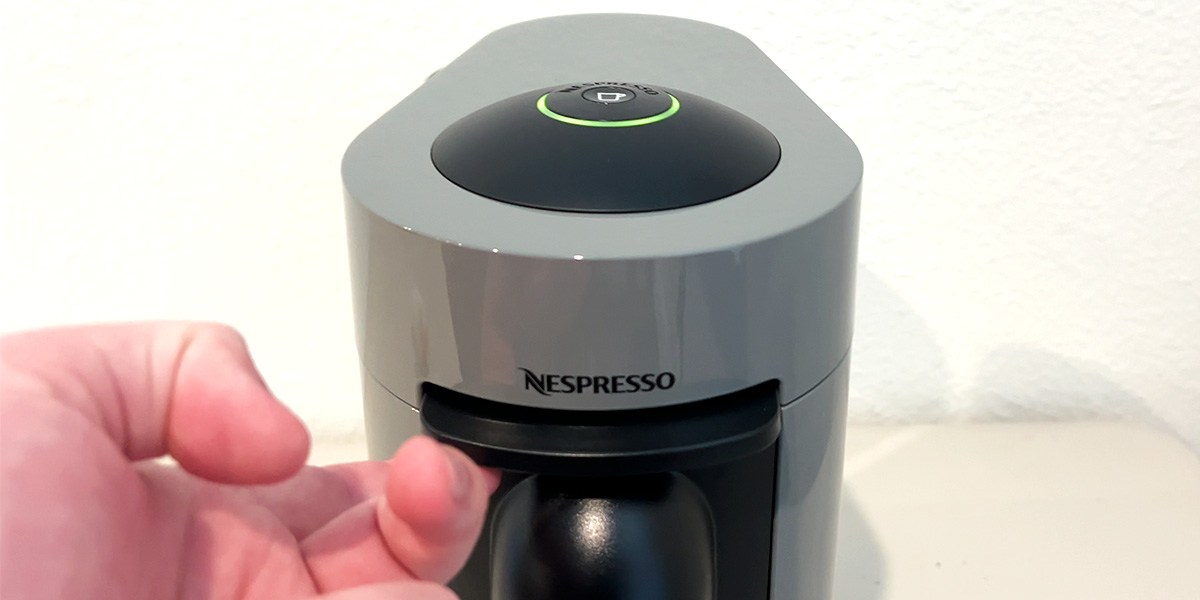 Closeup of front of Nespresso Vertuo with hand