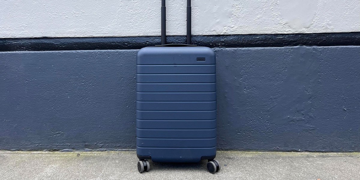 Blue Away Carry-On in front of blue and white wall